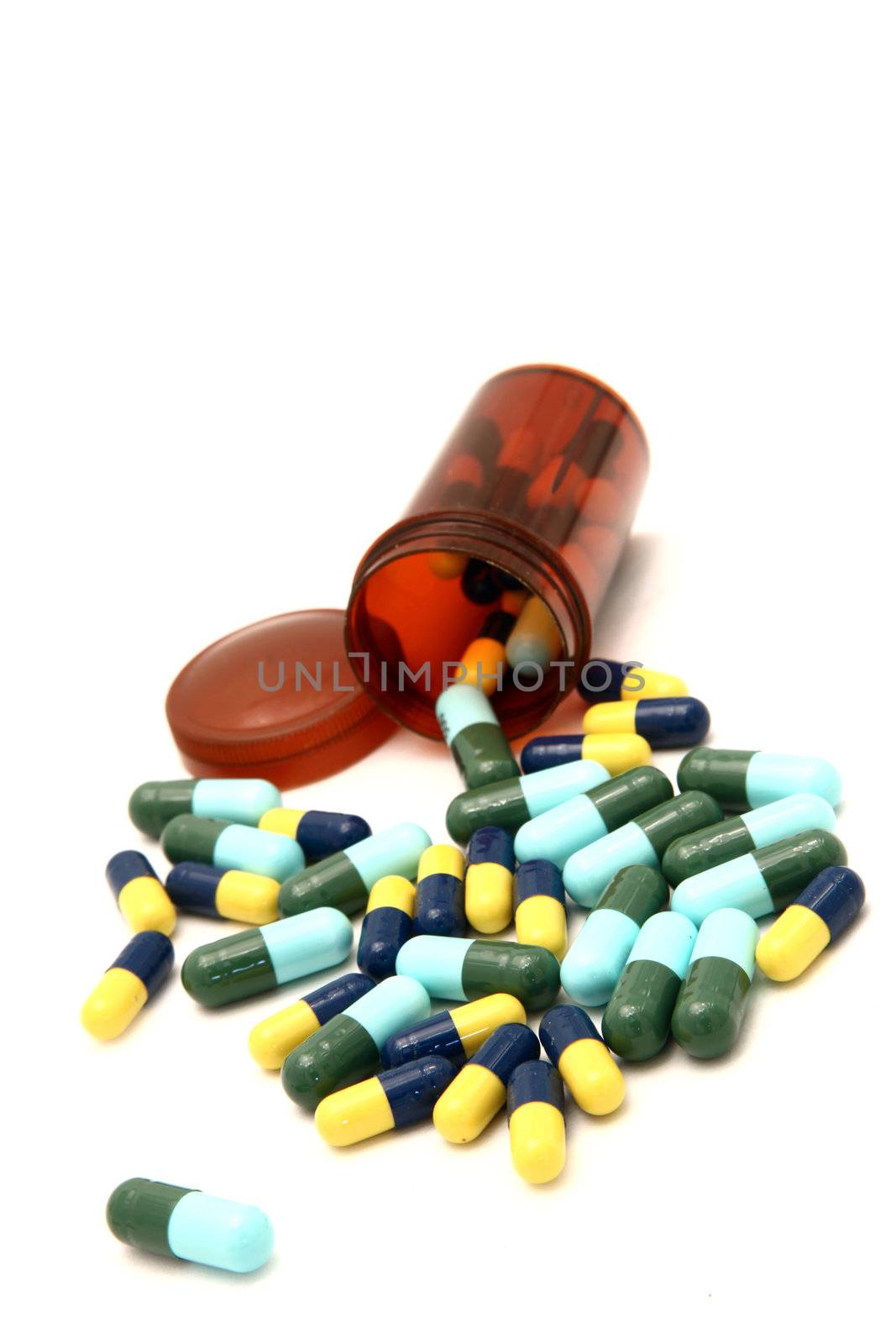 colorful capsule spilling out from pill bottle