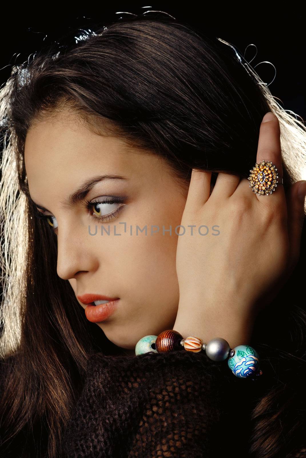 Photo of young model's profile with ring and bracelet