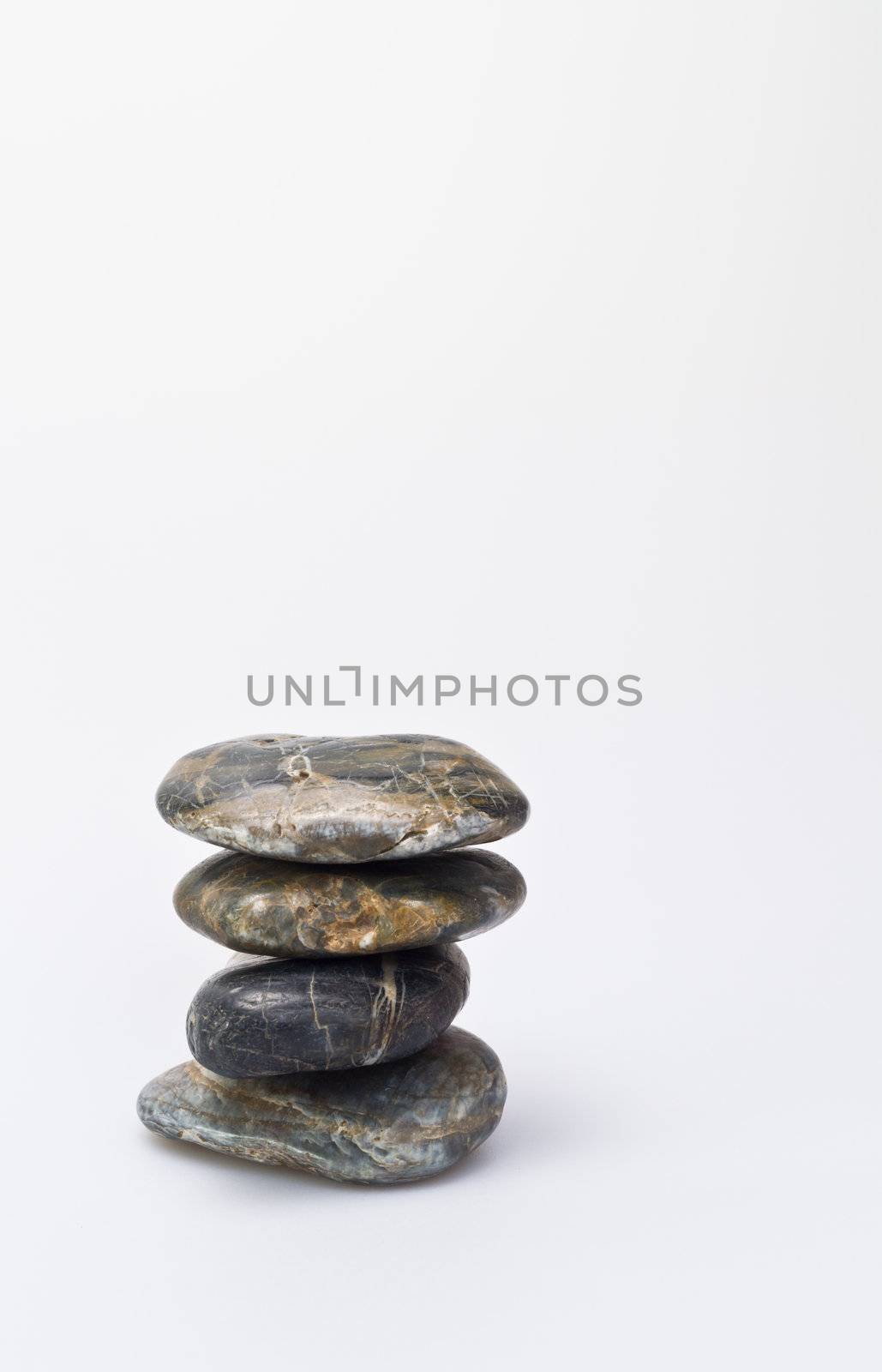 Baancing stones on white background left hand margin in portrait orientation