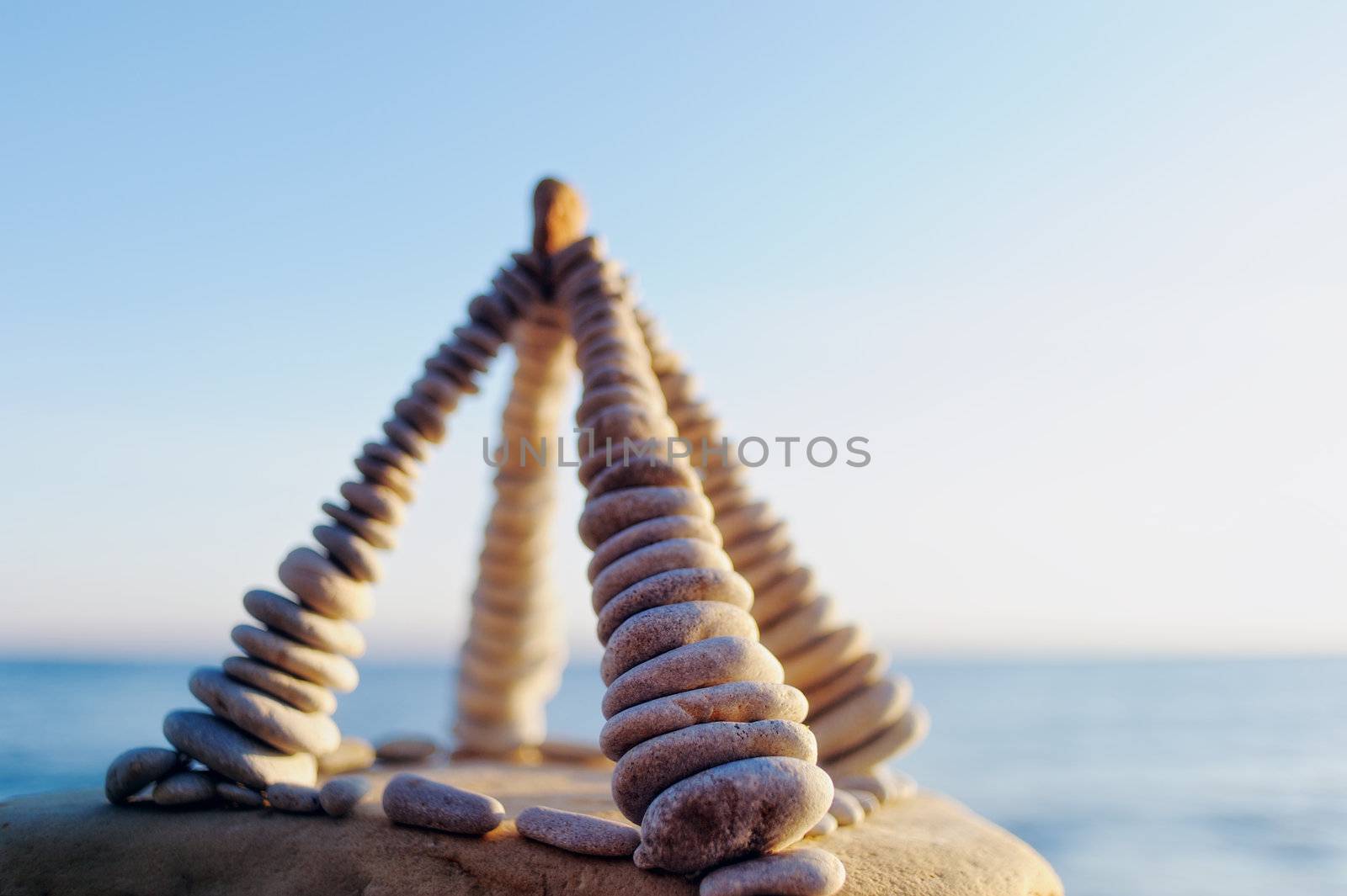 Pyramidal group of small pebbles in the balance on the seacoast