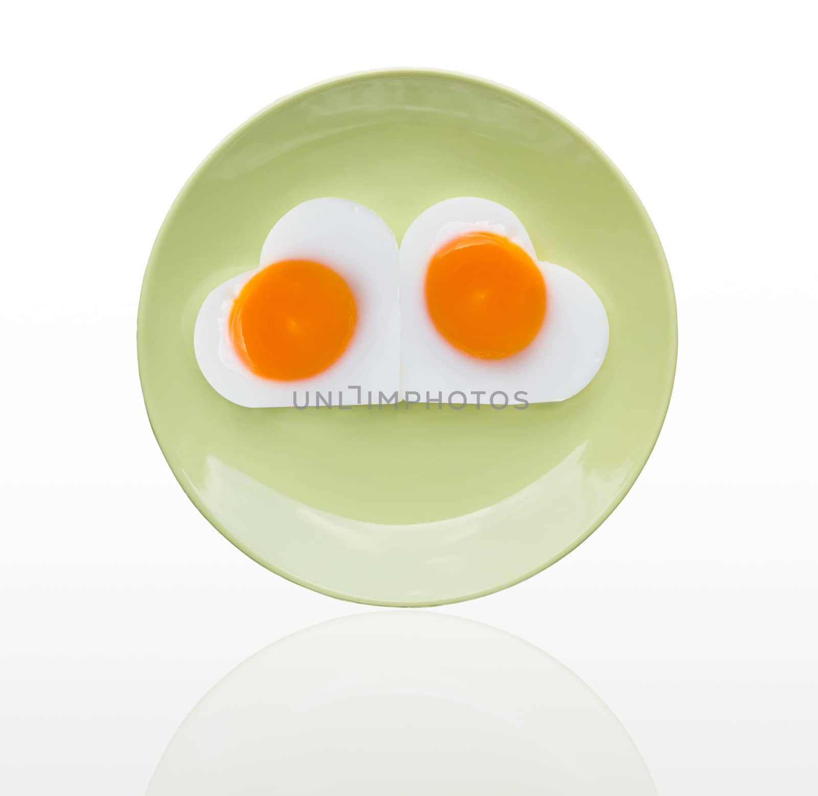 Fried egg  heart on green dish by stoonn