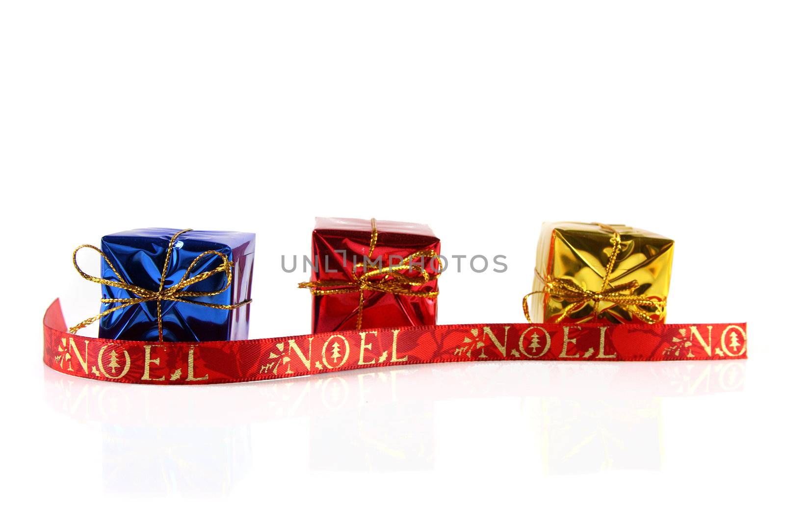 A studio shot on a solid white background of some holiday gifts and a decorative ribbon.
