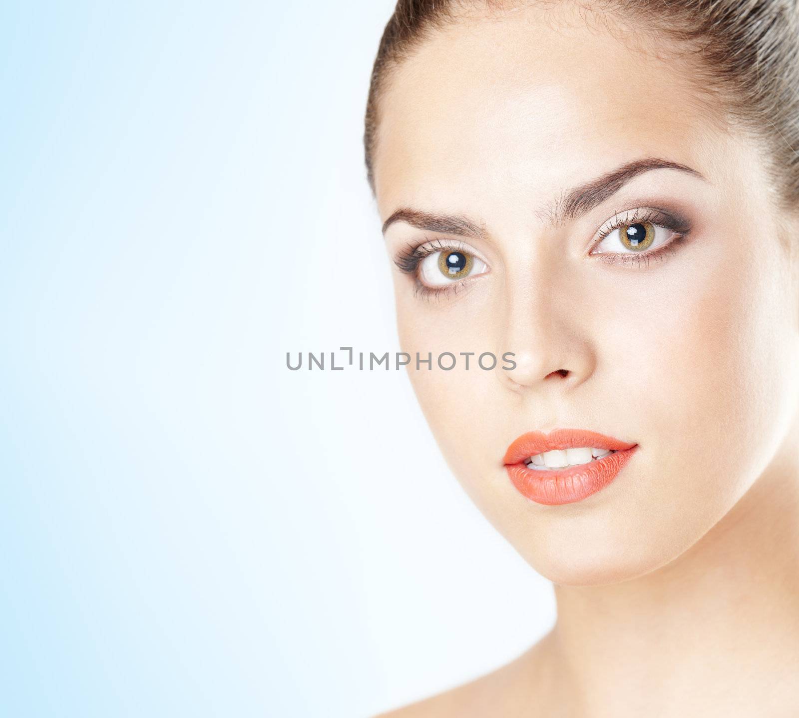 Close-up portrait of the beautiful woman with perfect makeup on a blue background