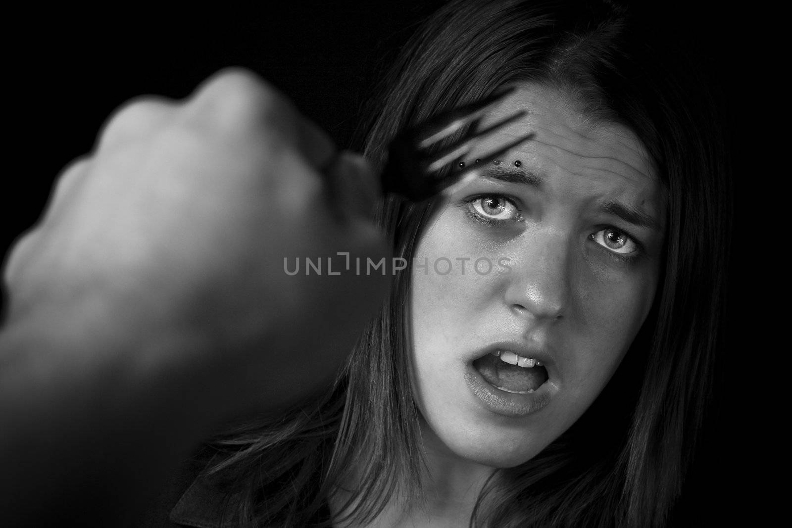 Shot of an intimidated girl, fearful and terrified.

Studio shot.