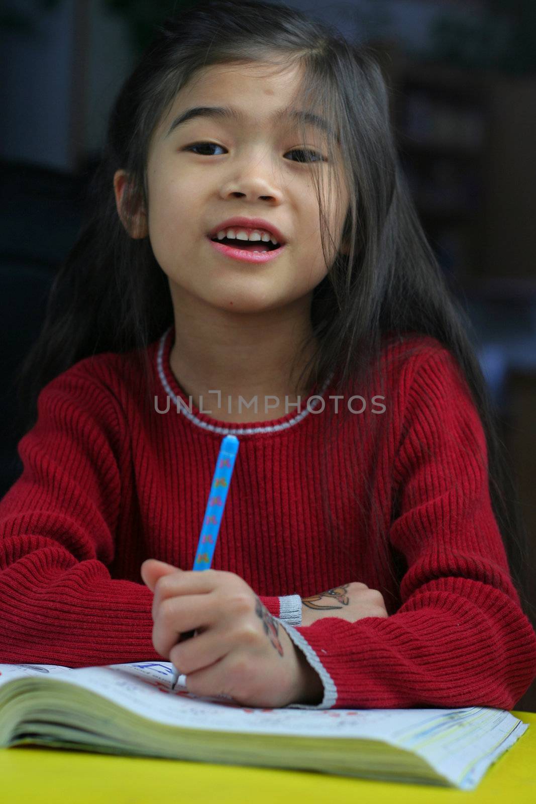 Six year old girl doing her homework at night.