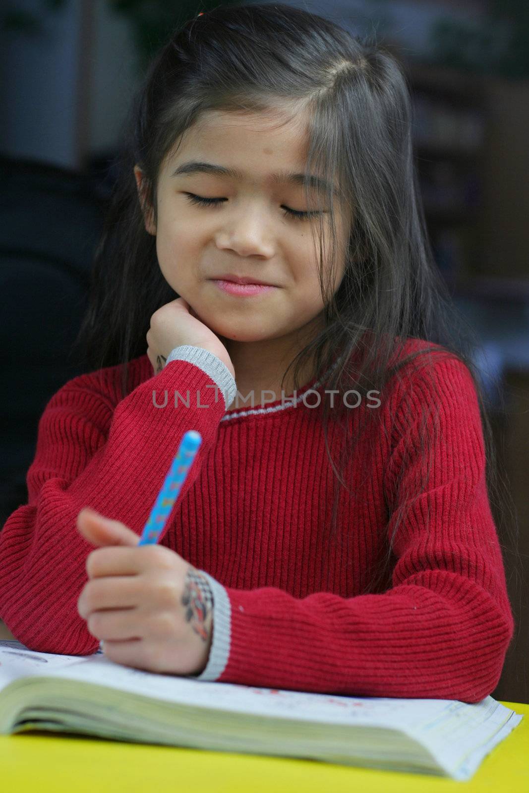 Six year old girl doing her homework at night.