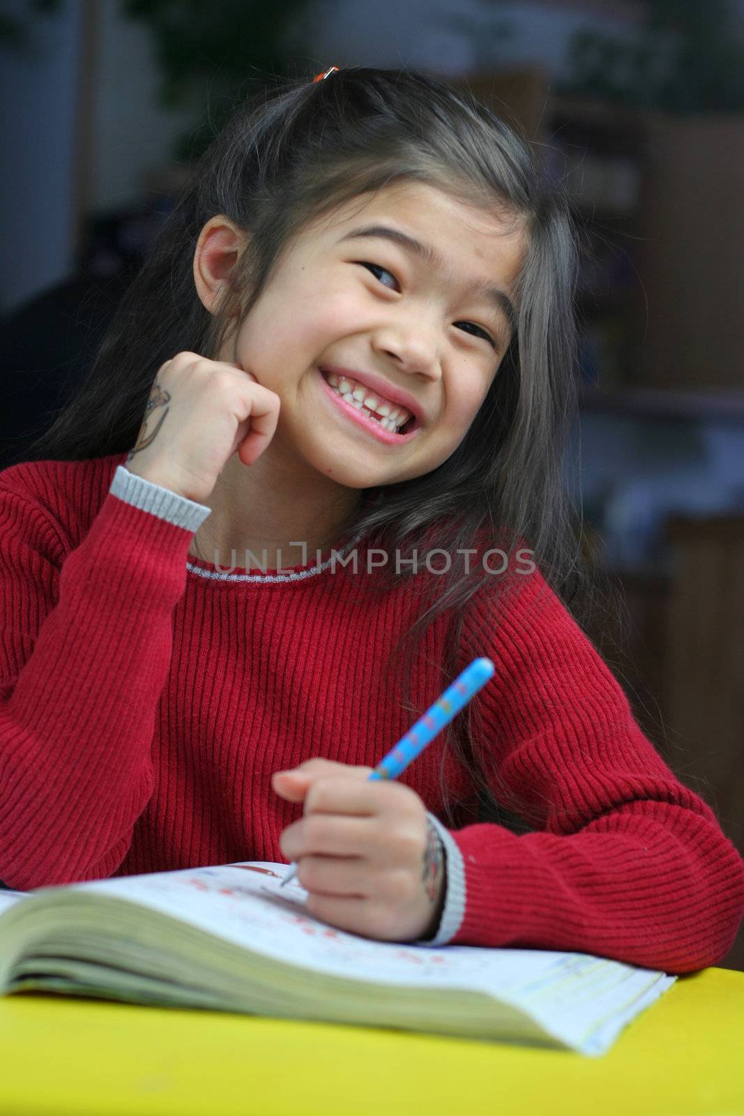 Six year old girl doing her homework at night.