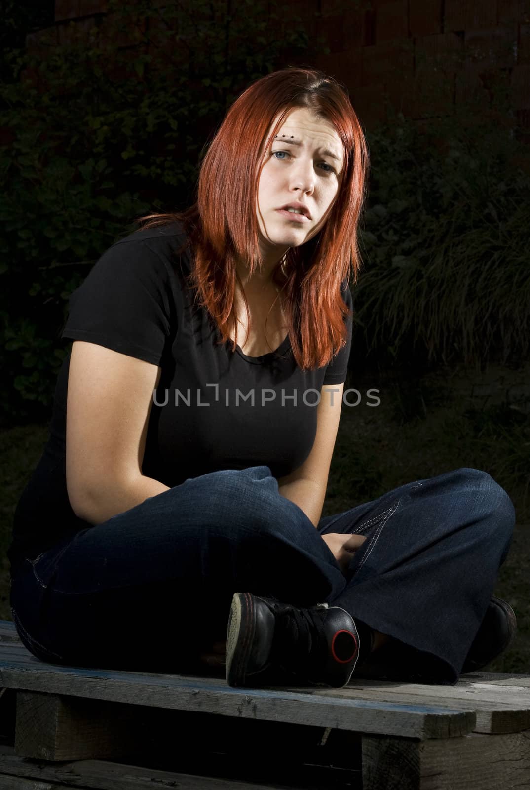 Girl siting on wood, flash lighting, redhead.

Lit with two offcamera flashes.