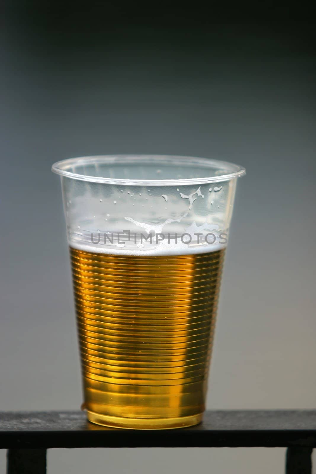 Plastic glass with beer on a dim background