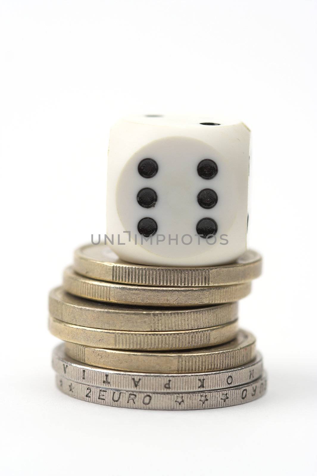 Dice on stack of coins,close up,over white