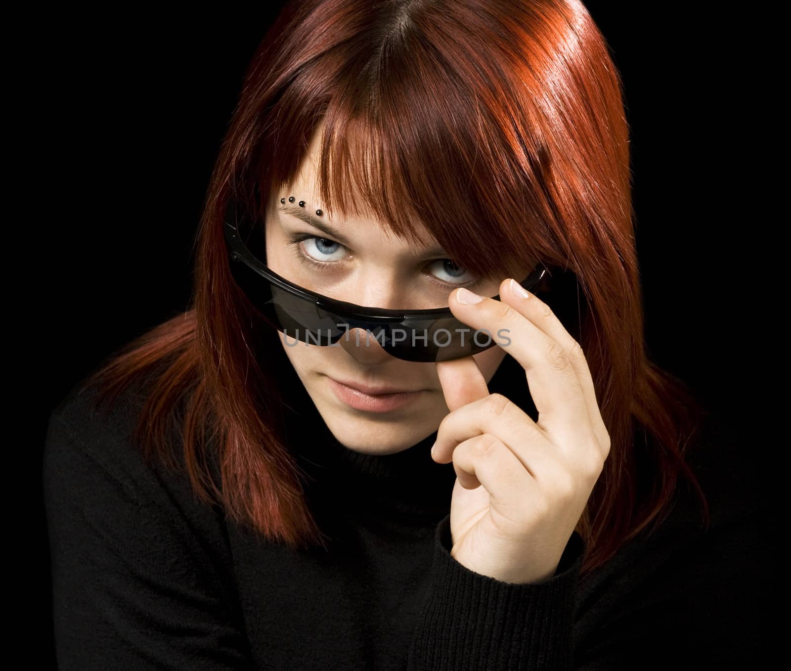 Girl wearing sunglasses and staring through them at the camera, seductively.

Shot in studio.