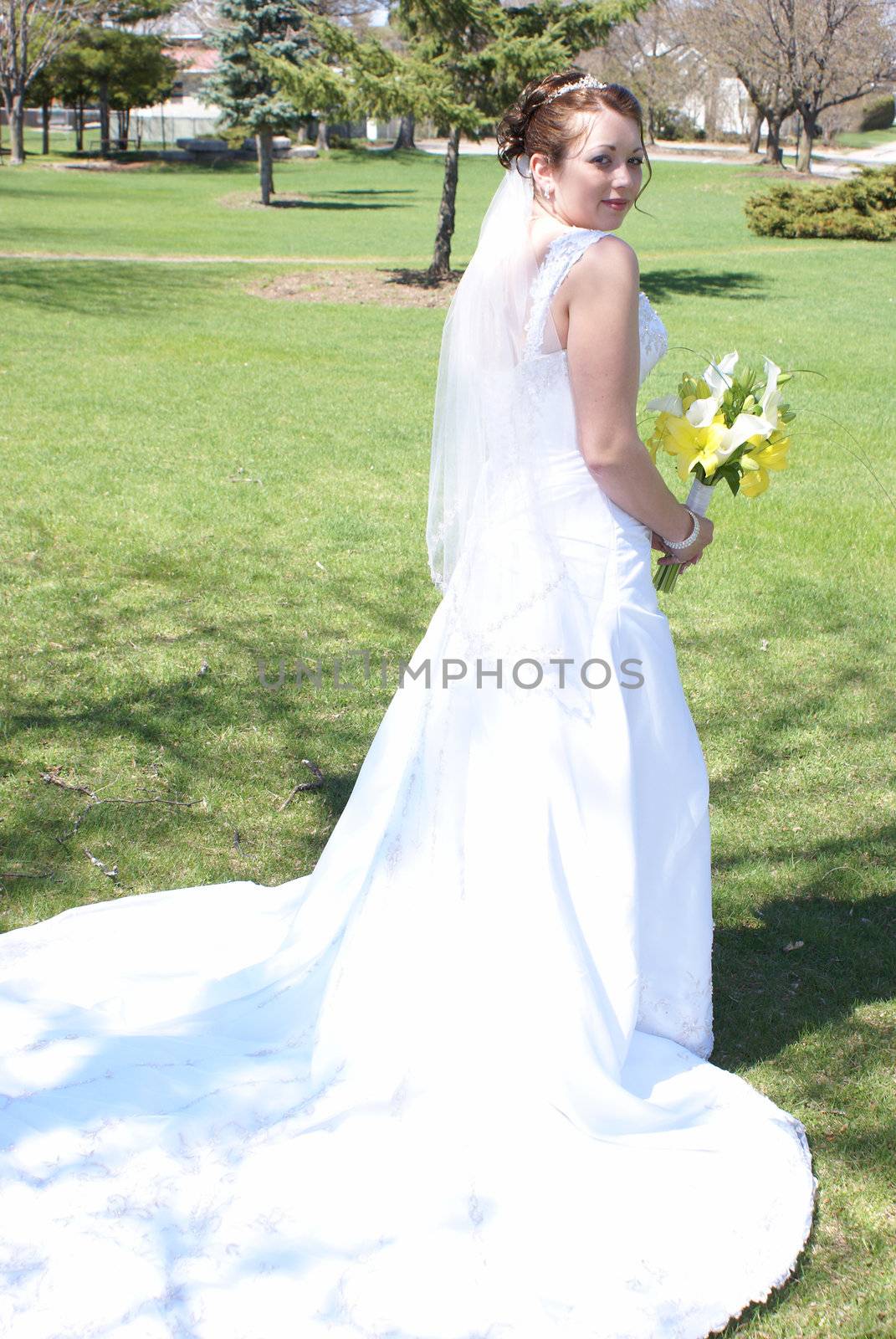 A newly wed bride shows the back of her dress.