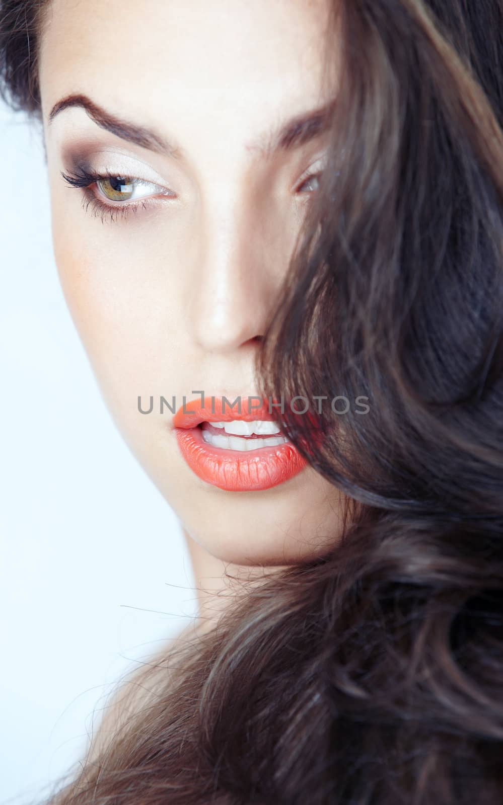 Close-up portrait of the beautiful woman with perfect makeup on a blue background