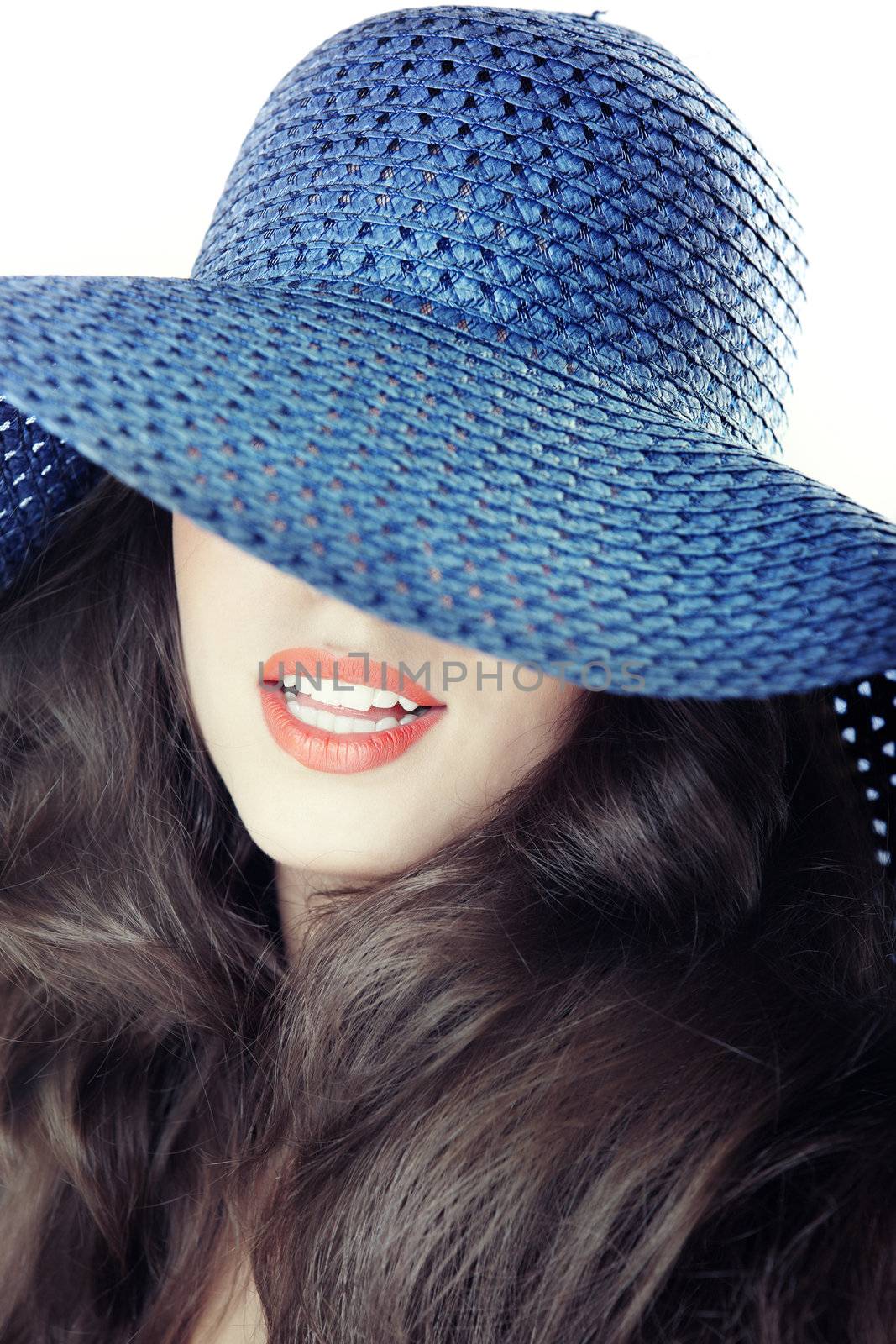 Smiling lady in blue summer hat. Studio photo