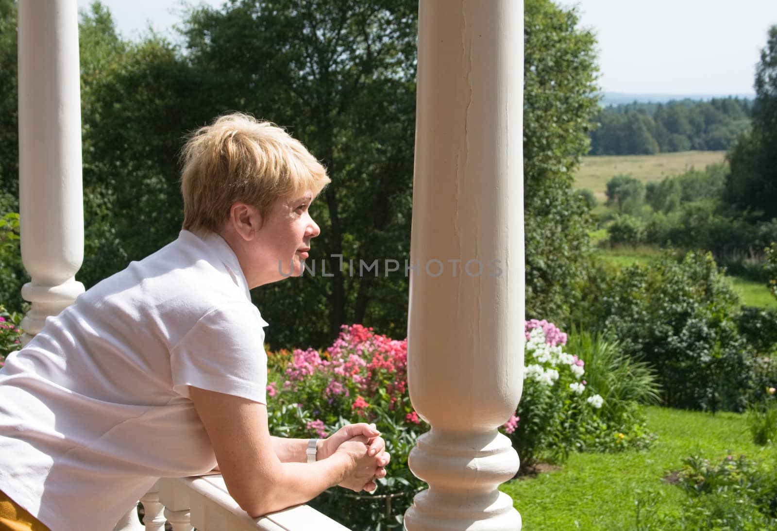 Woman looks at nature from building in rural terrain