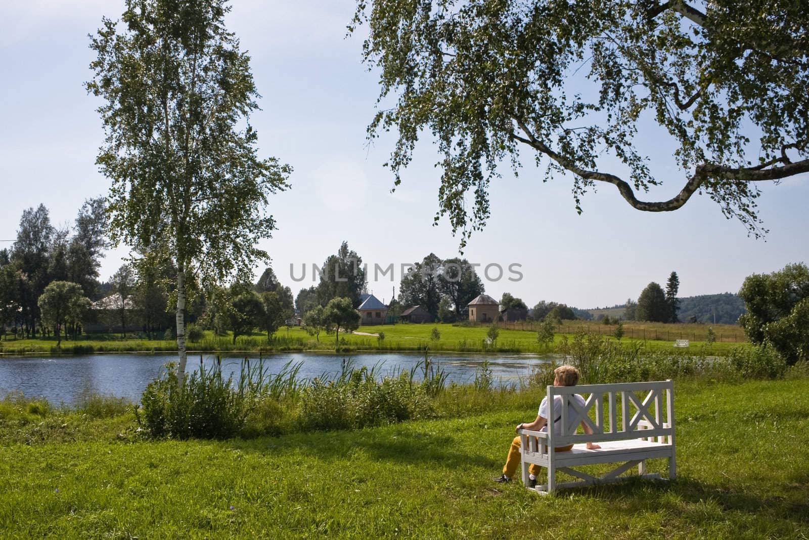 Eldery woman on a bench in the countryside