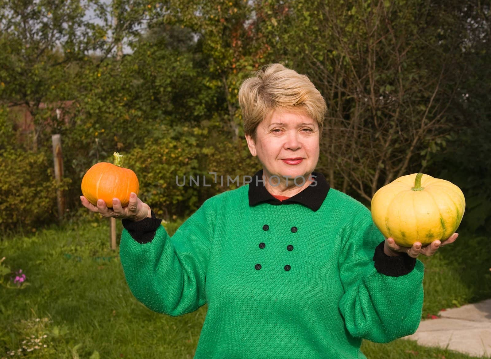 A woman demonstrates grown pumpkins