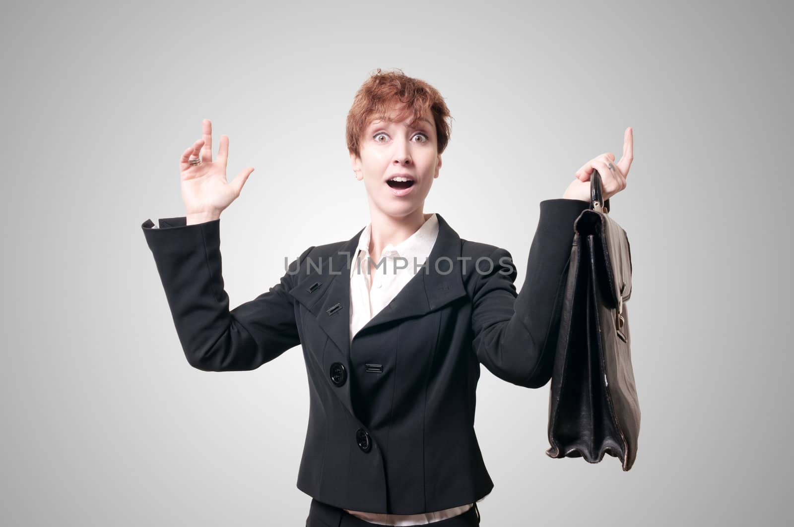 astonished business woman with briefcase on gray background