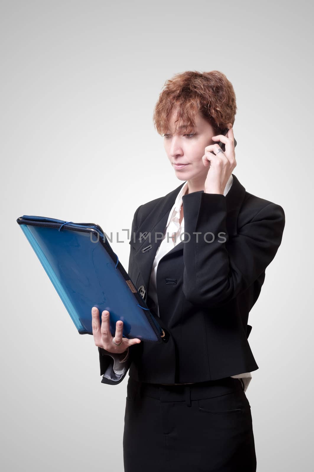 success business woman with briefcase and phone on gray background