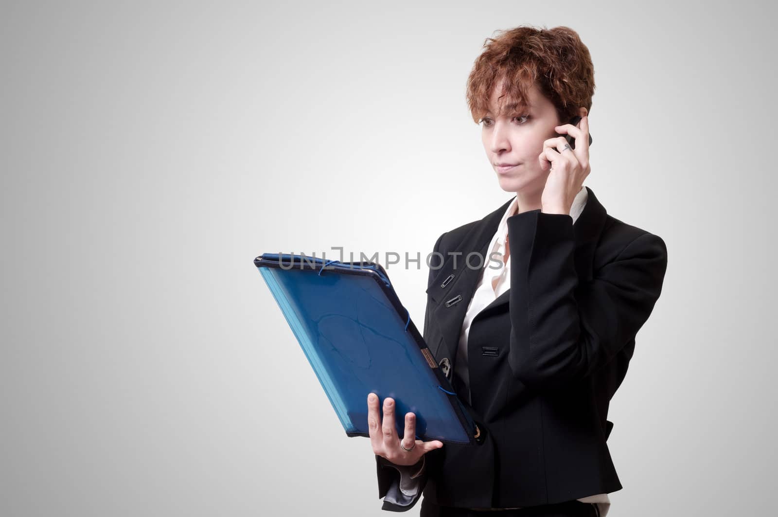 success business woman with briefcase and phone on gray background