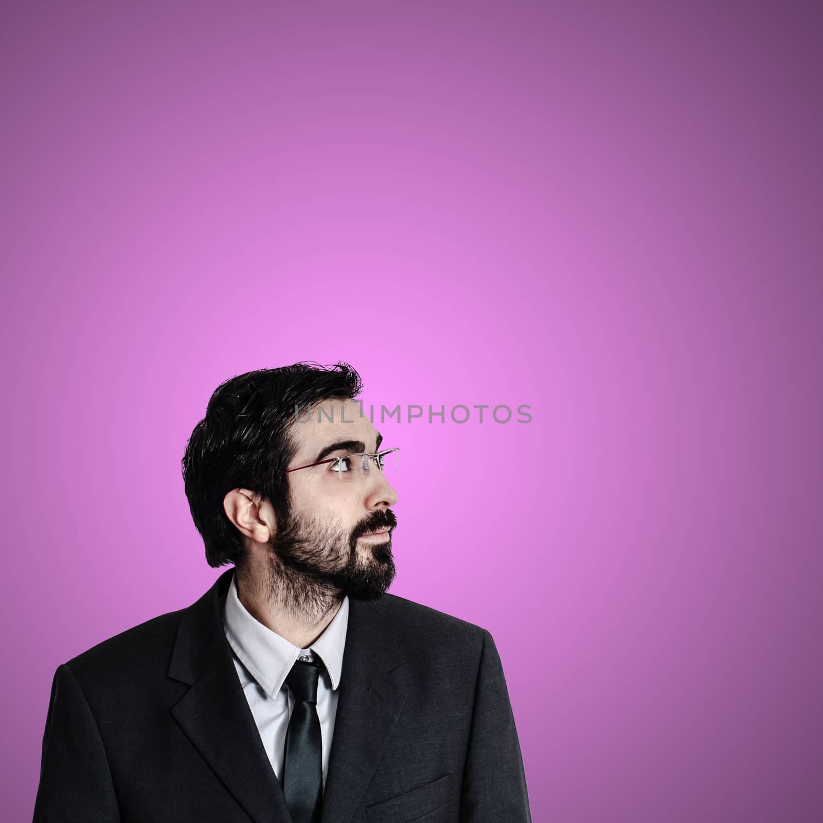 bearded business man looking up on pink background