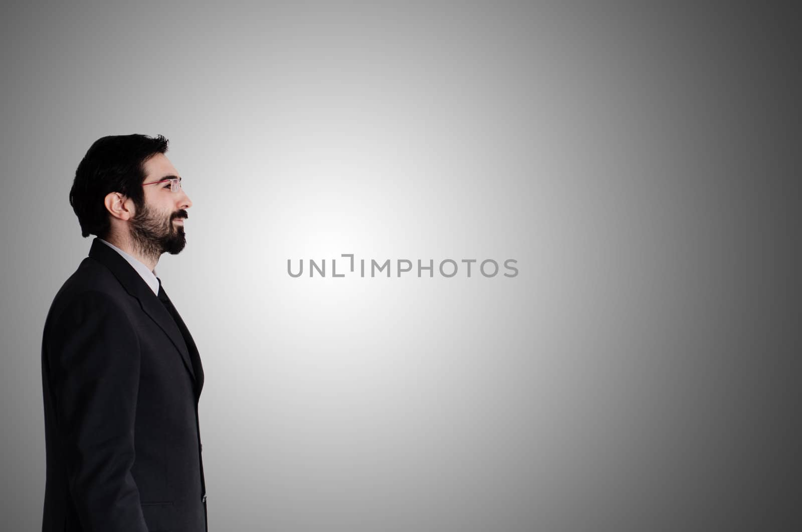 bearded business man looking up on gray background