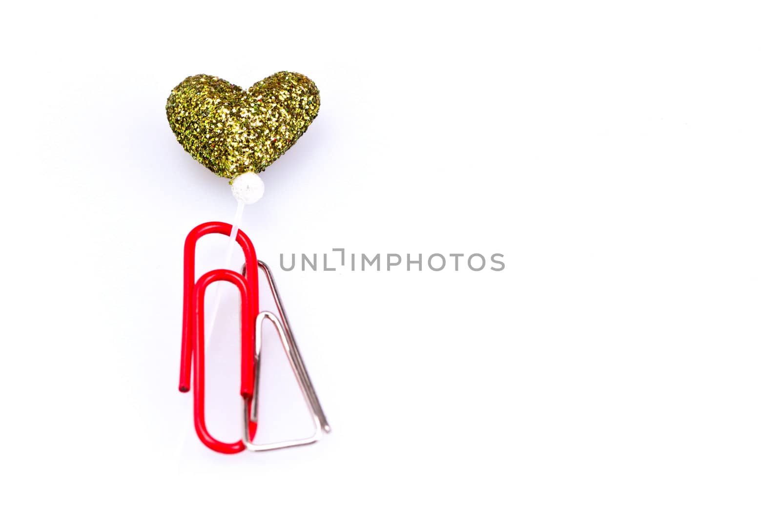 Metal and red plastic paerclip together with love symbol on white background with copy space