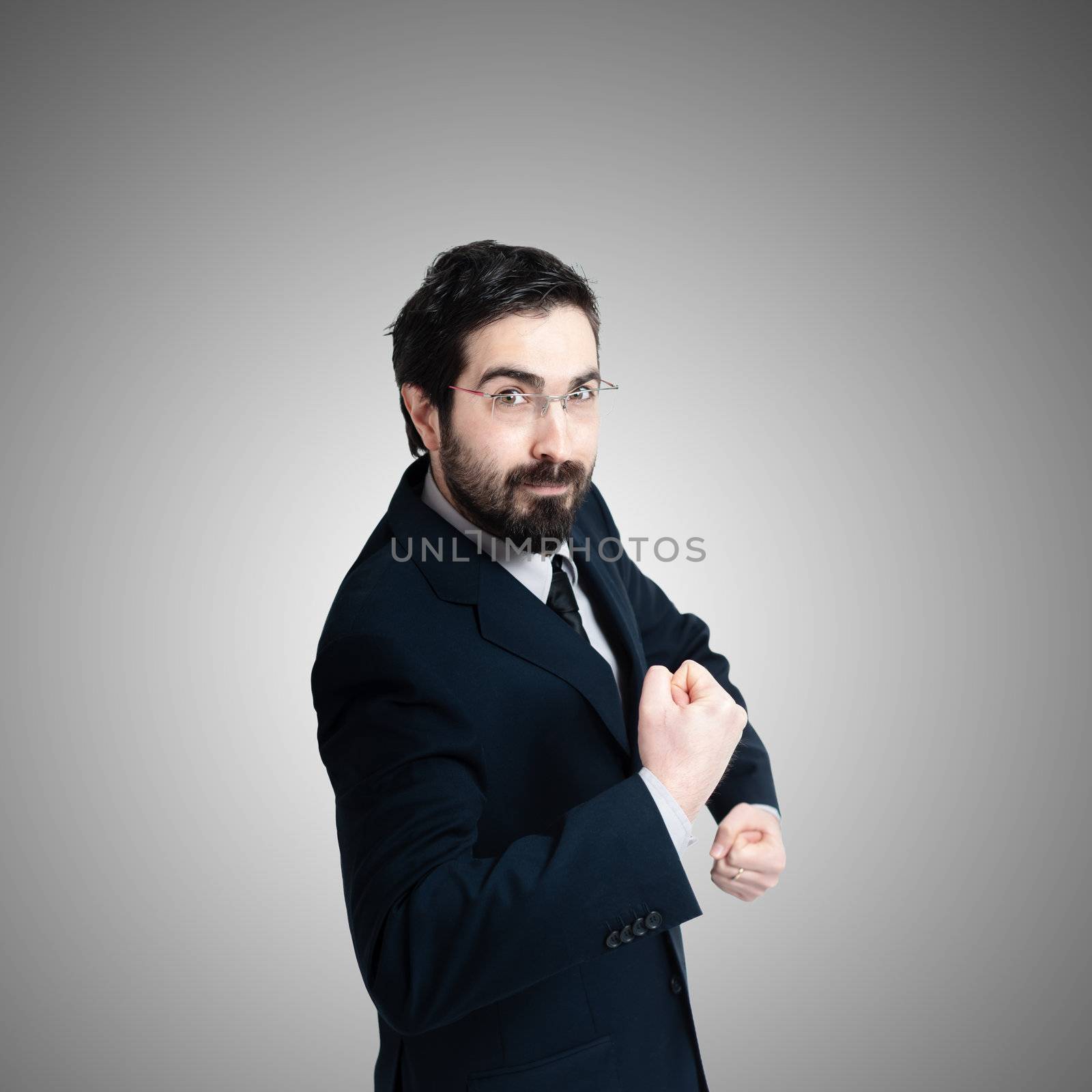 strong business man flexing muscle on gray background