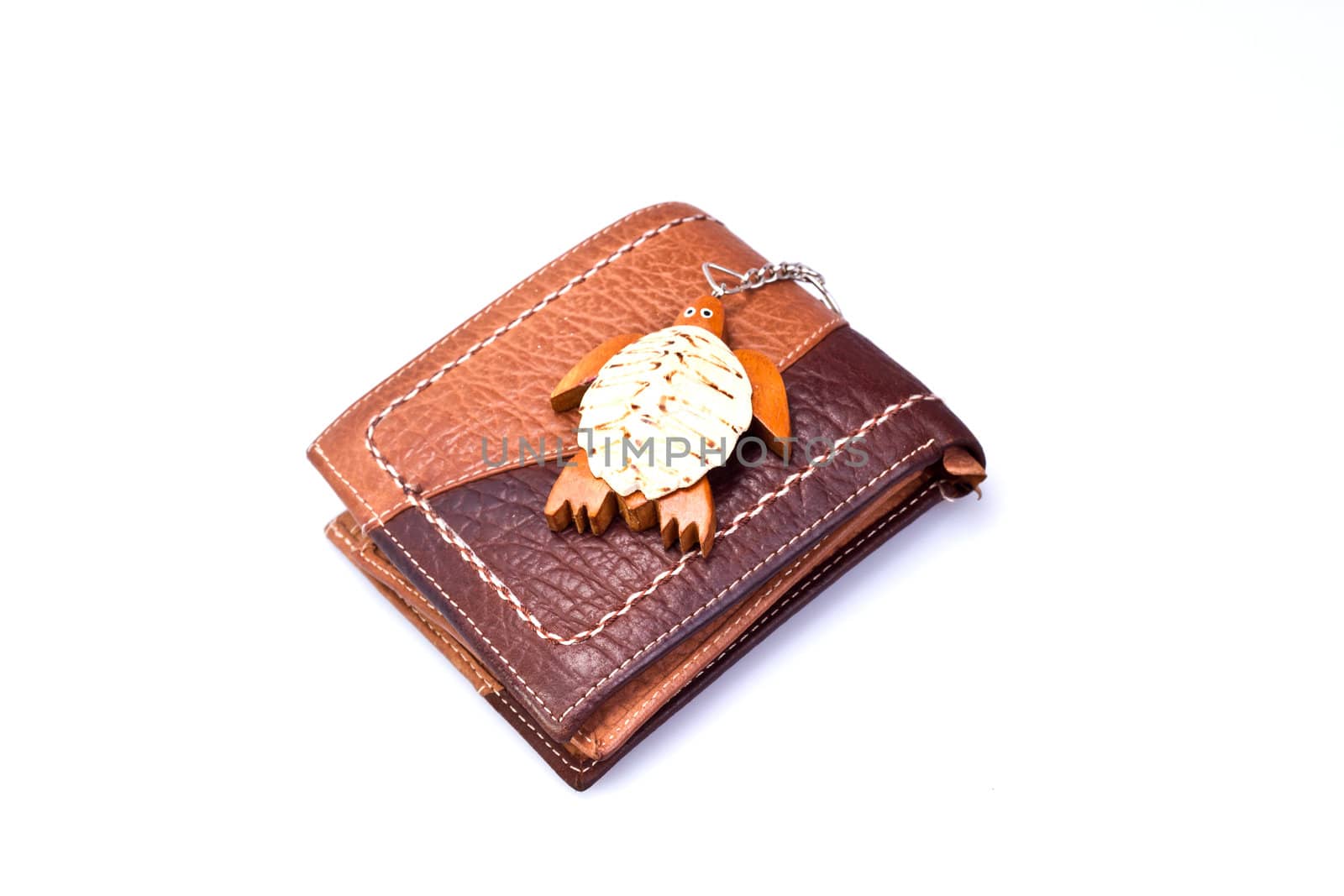 Brown Leather Wallet on white surface with wooden turtle keychain on top of it
