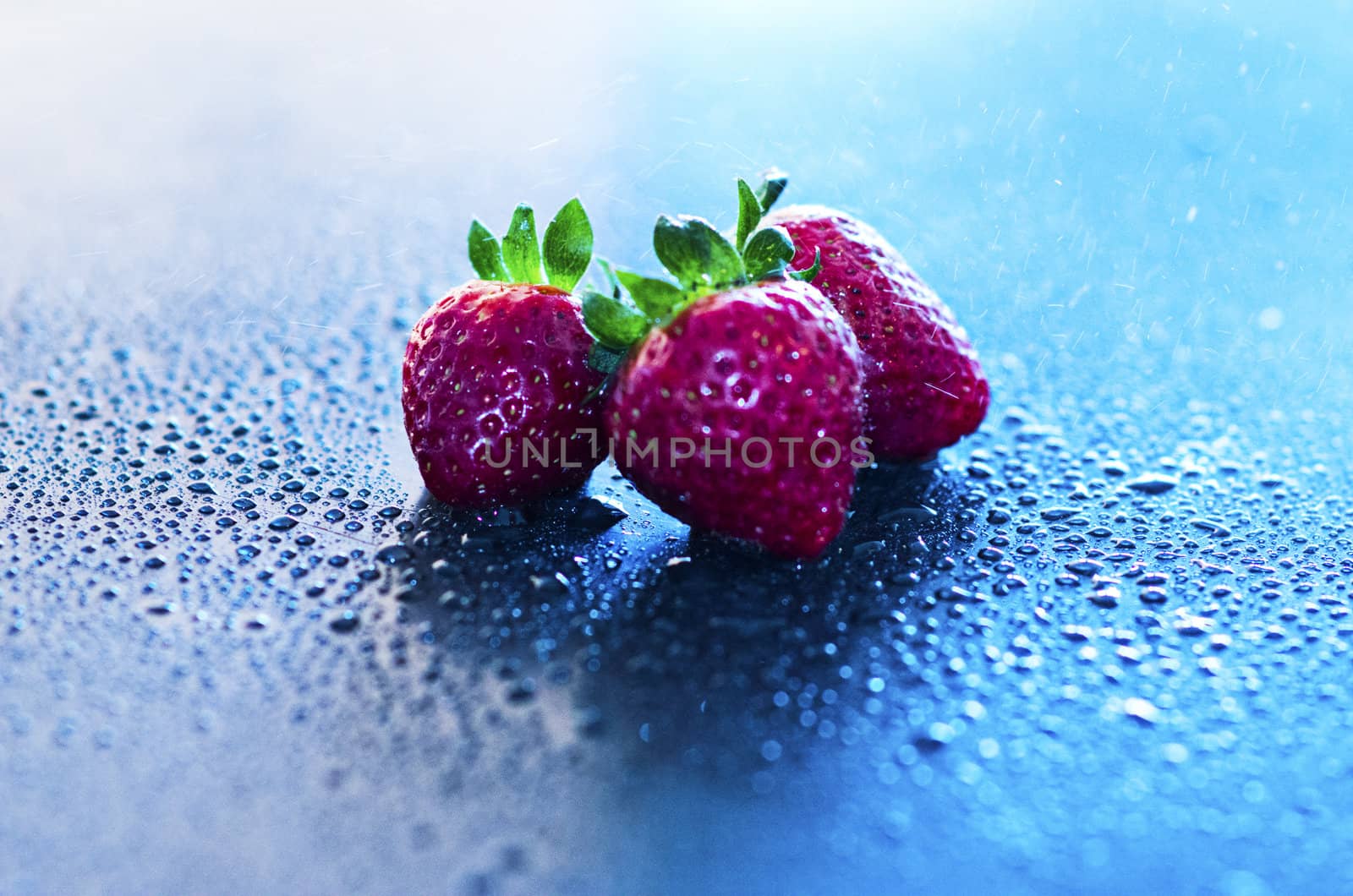 red fresh strawberries in drop of water