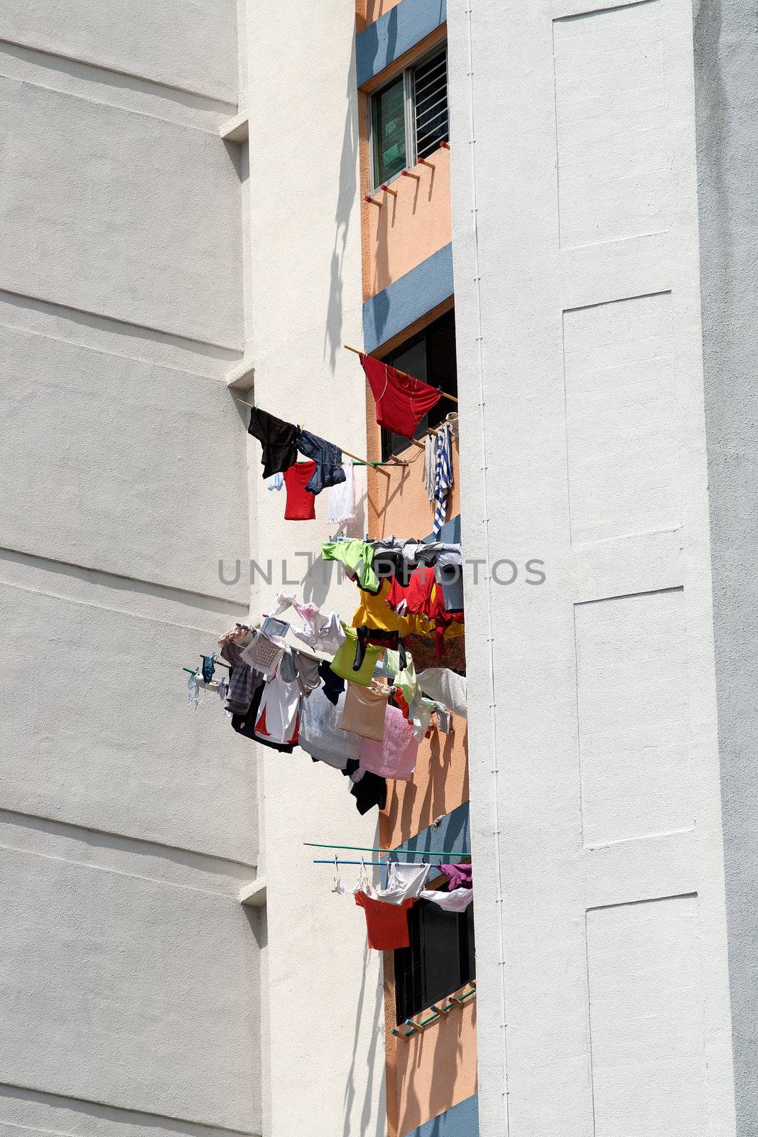 Laundry drying from windows, Singapore by ints