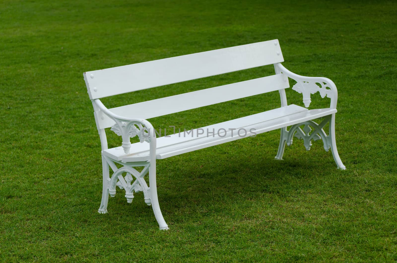 White Bench on green lawn by nuttakit