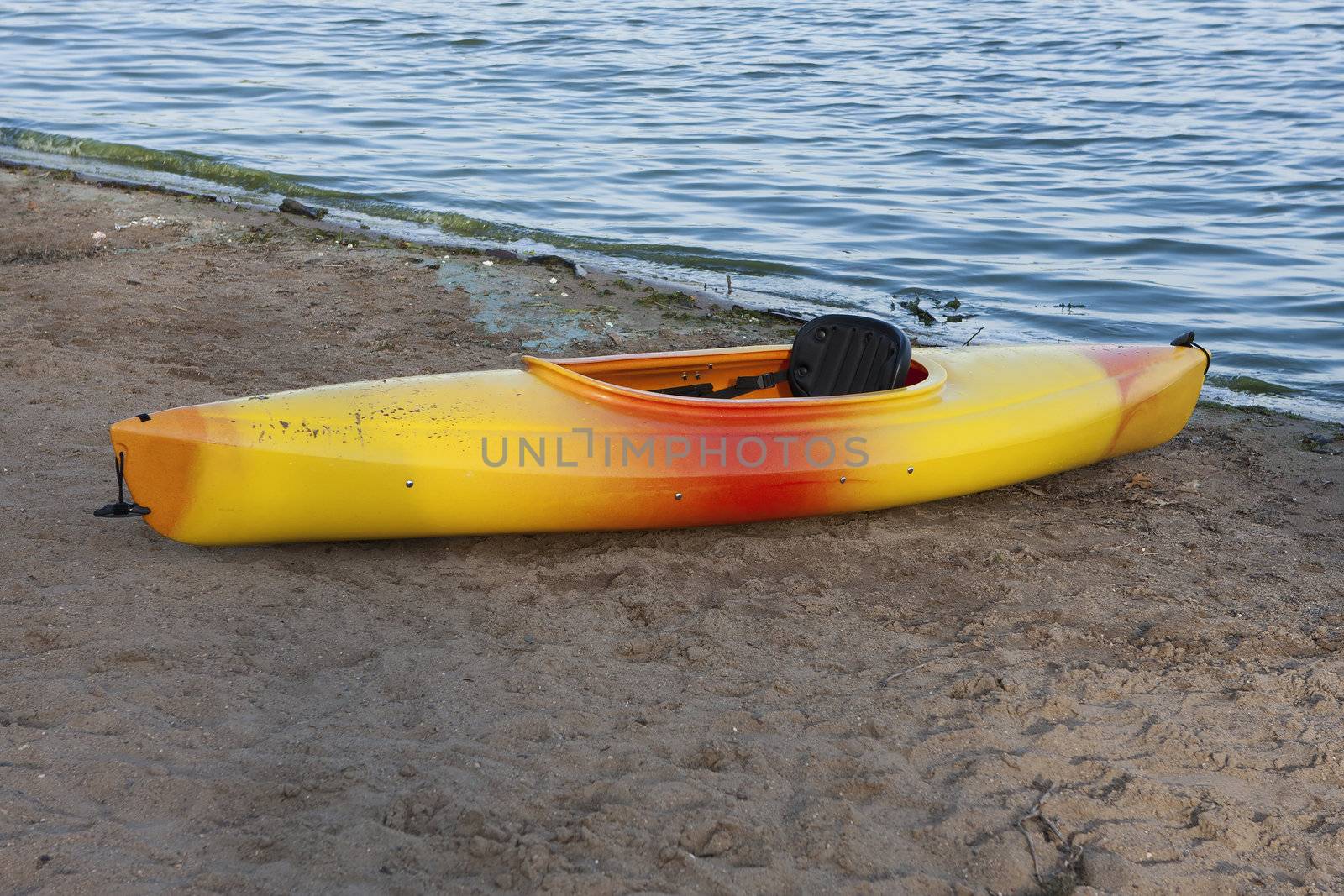 Single yellow kayak on the beach at twilight. 