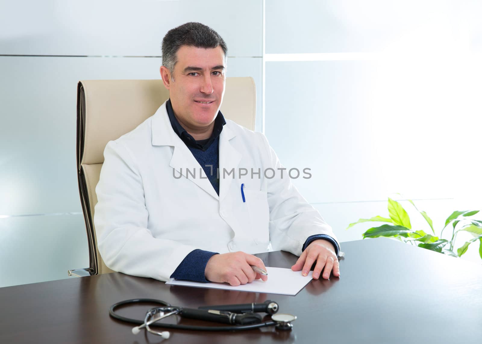 Doctor man sitting in hospital office desk portrait by lunamarina