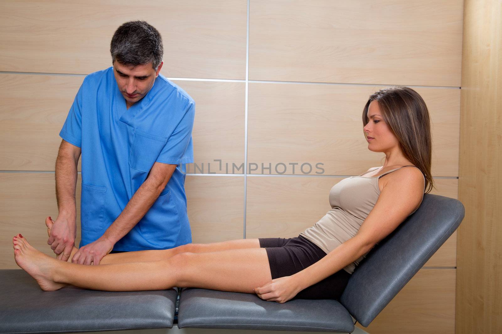 Ankle joint mobilization therapy of doctor man to patient woman in hospital