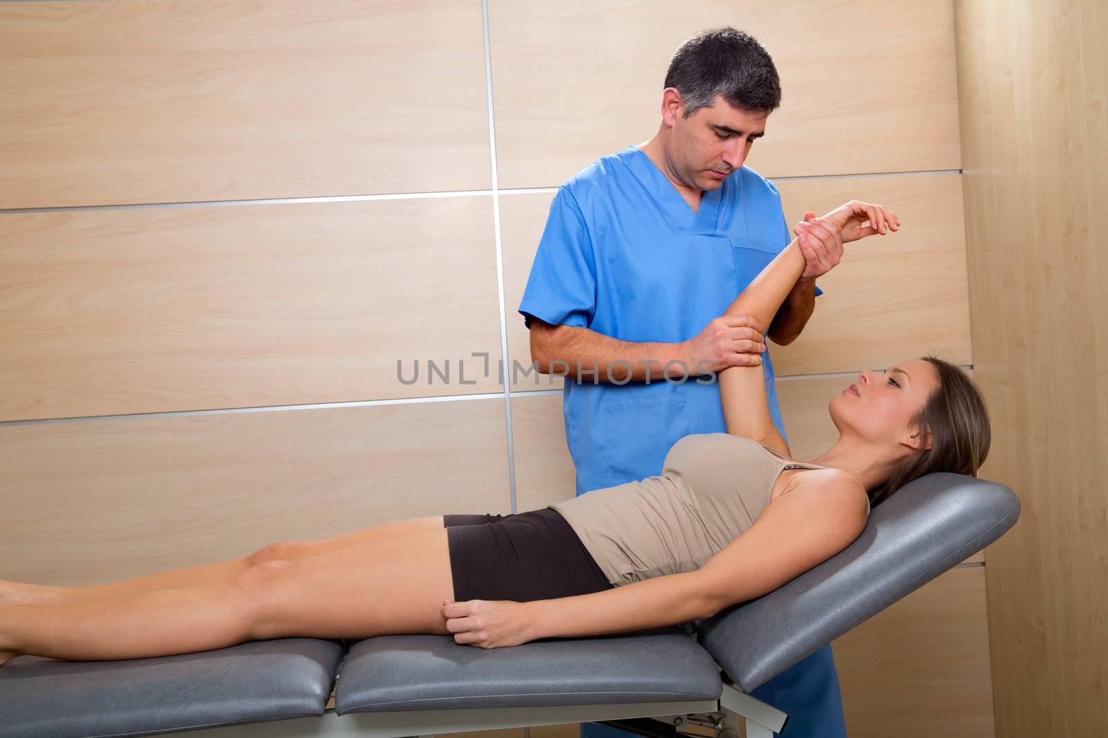 Shoulder physiotherapy doctor therapist and woman patient by lunamarina