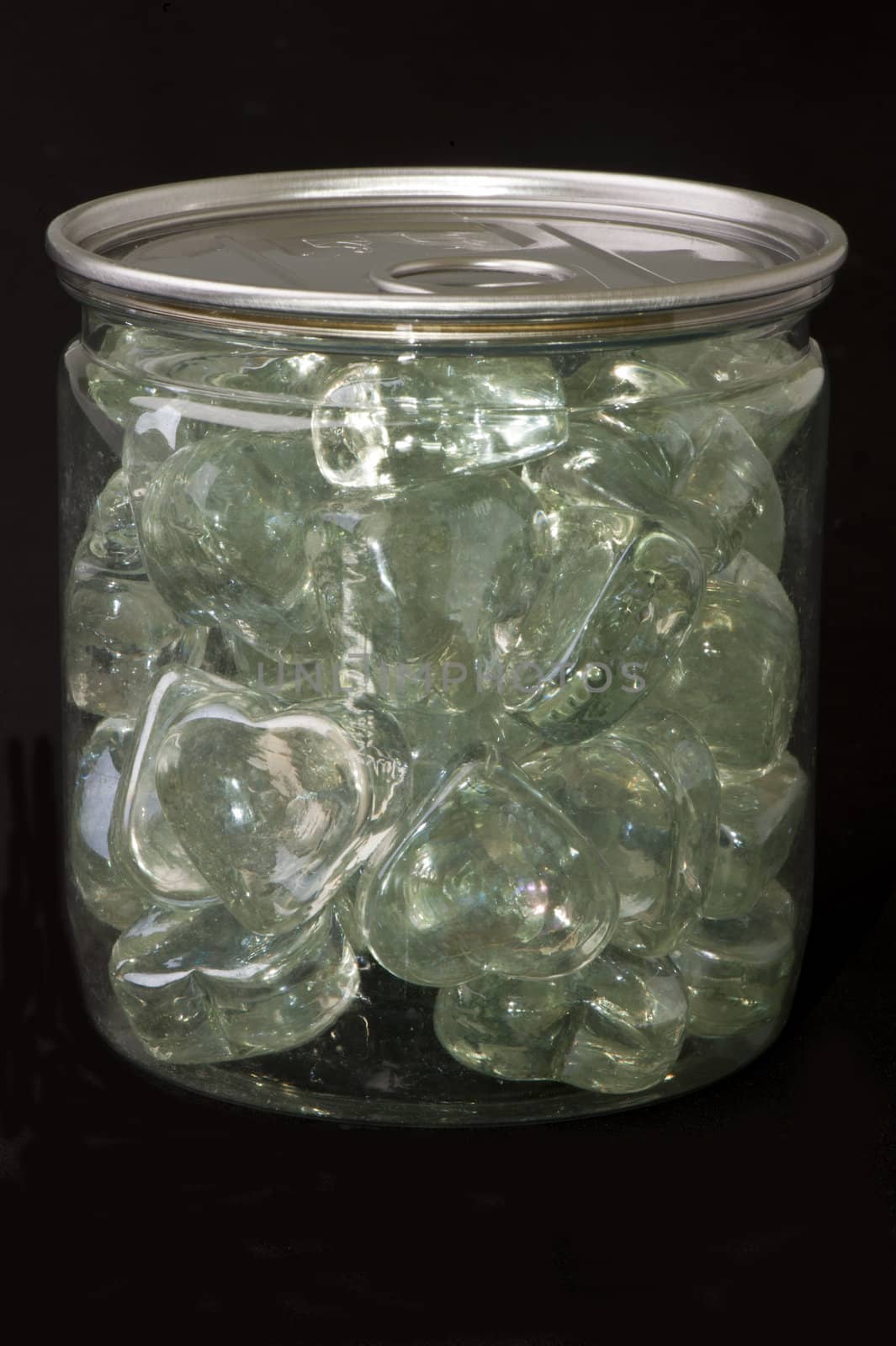 Jar with crystal heart-shaped on black background
