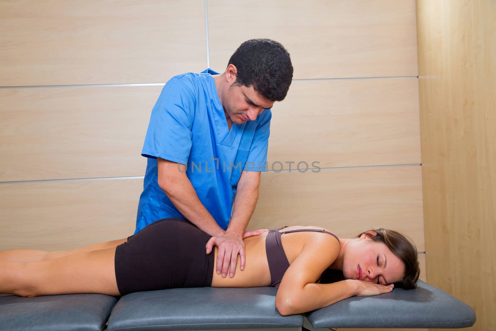 Massage therapy by physiotherapist on back torso to beautiful woman relaxed