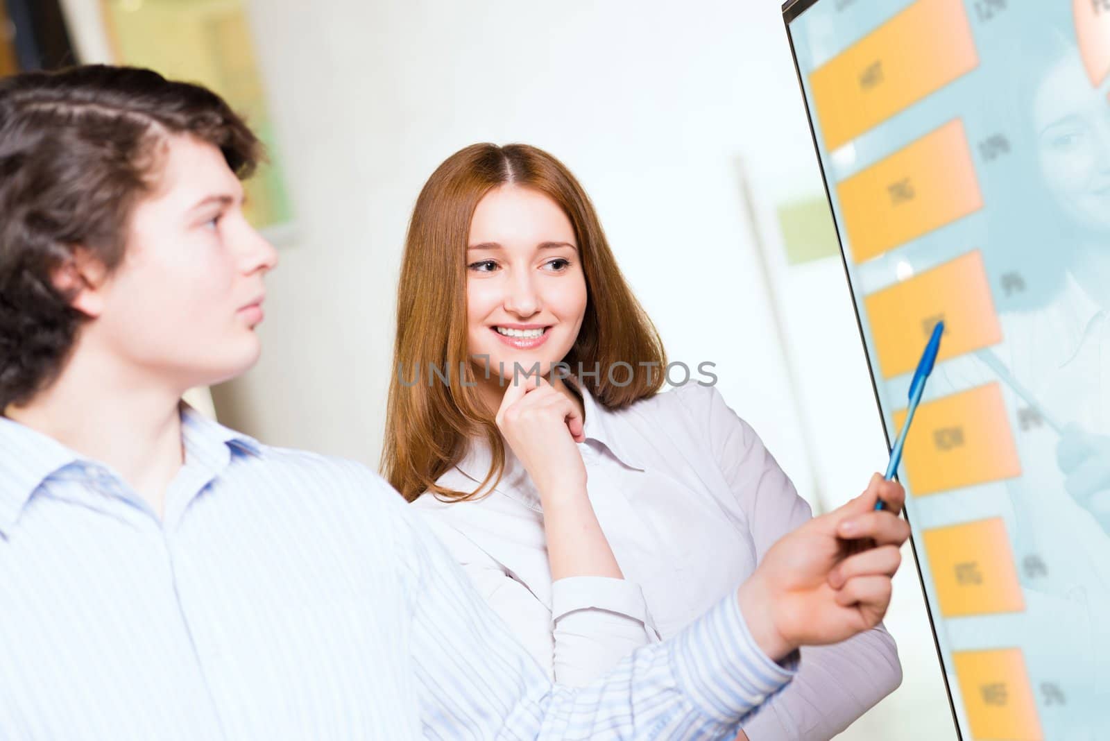 attractive business woman with a colleague discussing charts and graphs on the screen, Collaboration
