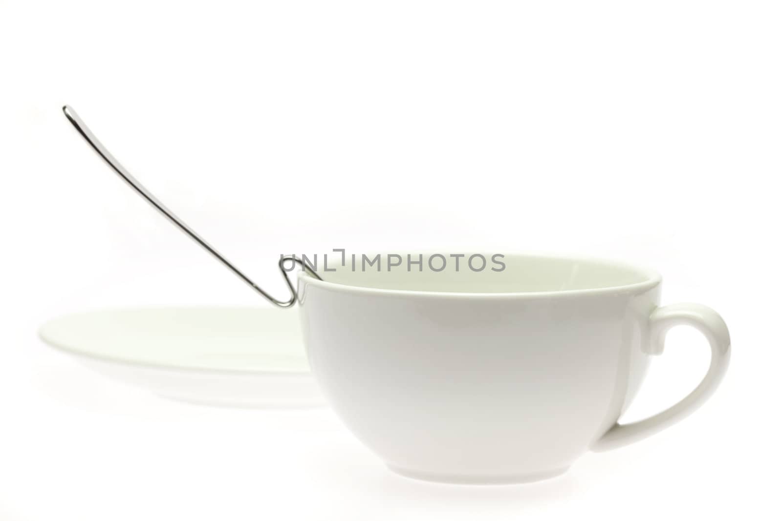 white cup, saucer and spoon isolated on white by jannyjus