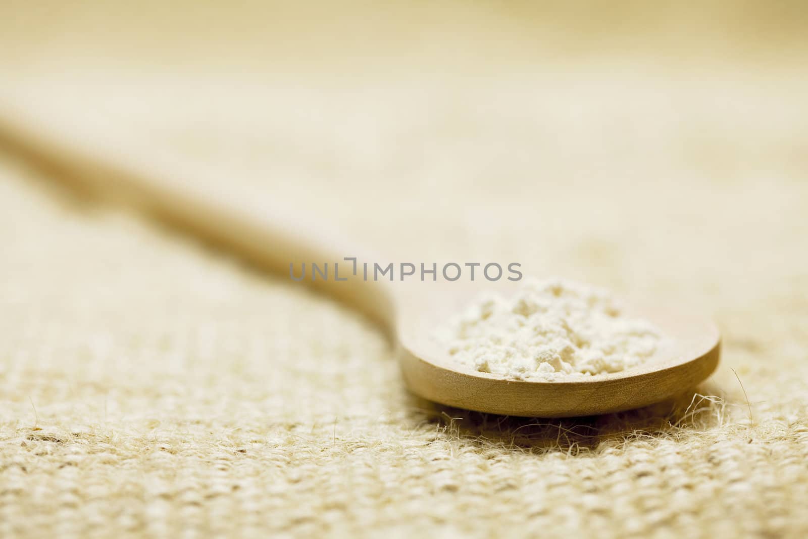 flour in a spoon on a  linen fabrics by jannyjus