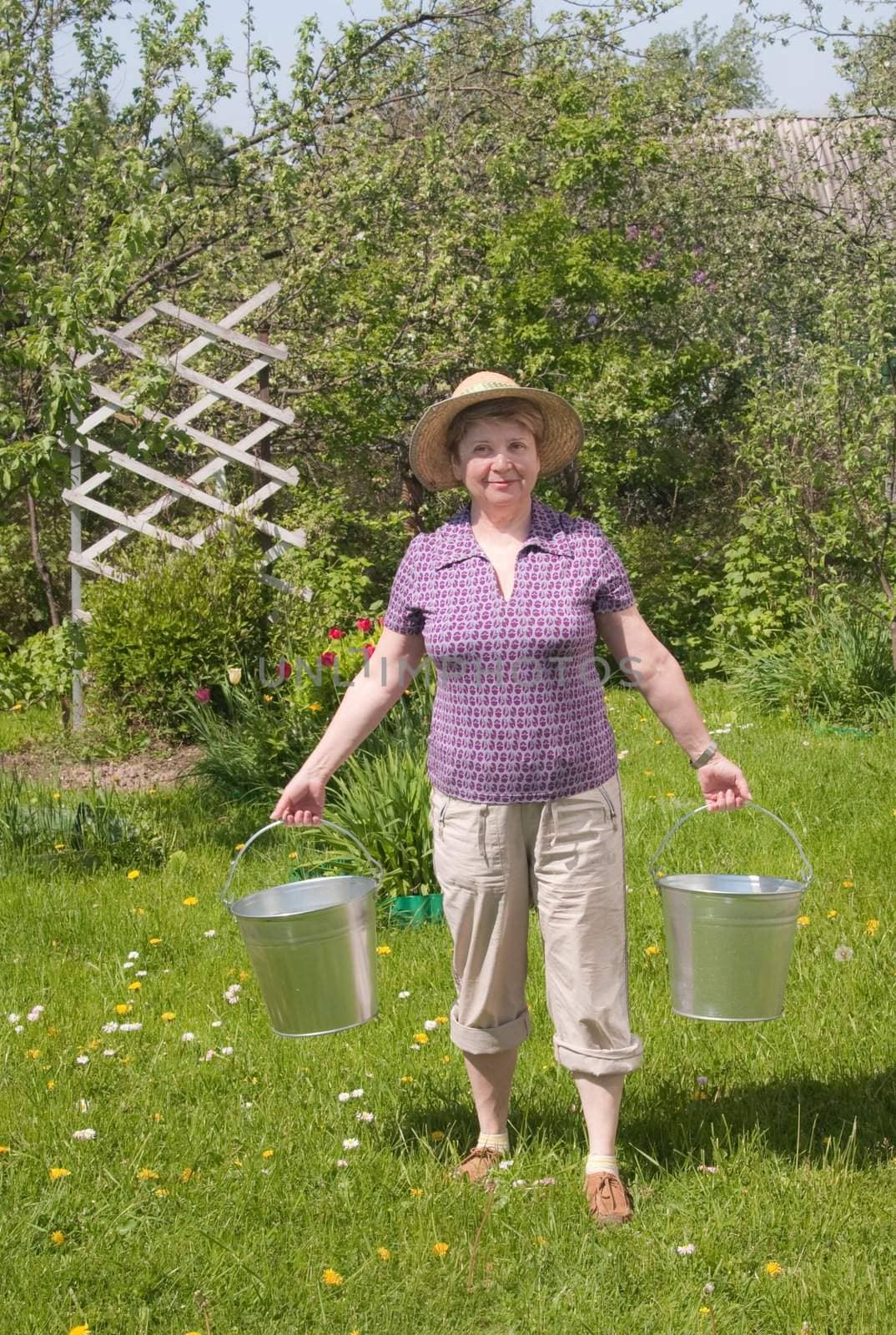 The rural woman with a bucket in hands