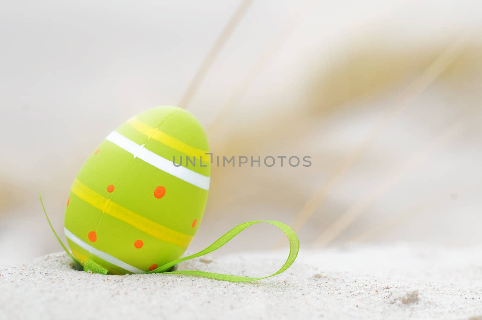 Easter decorated egg on sand. Beach in the background