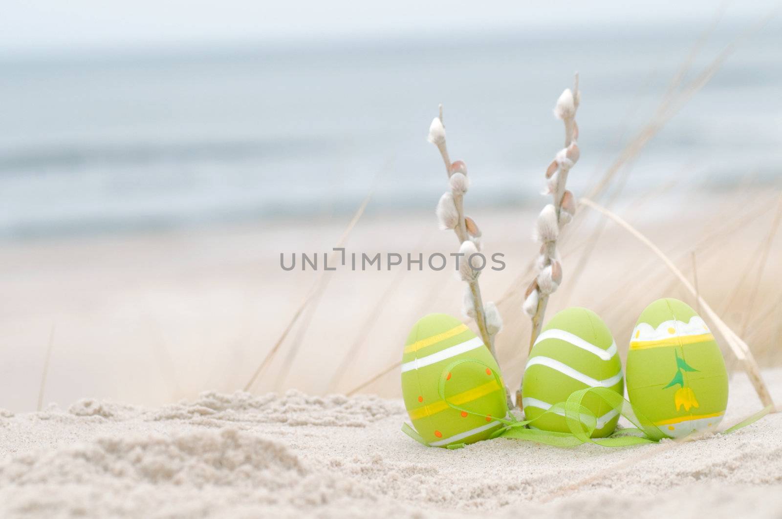 Easter decorated eggs on sand by photocreo