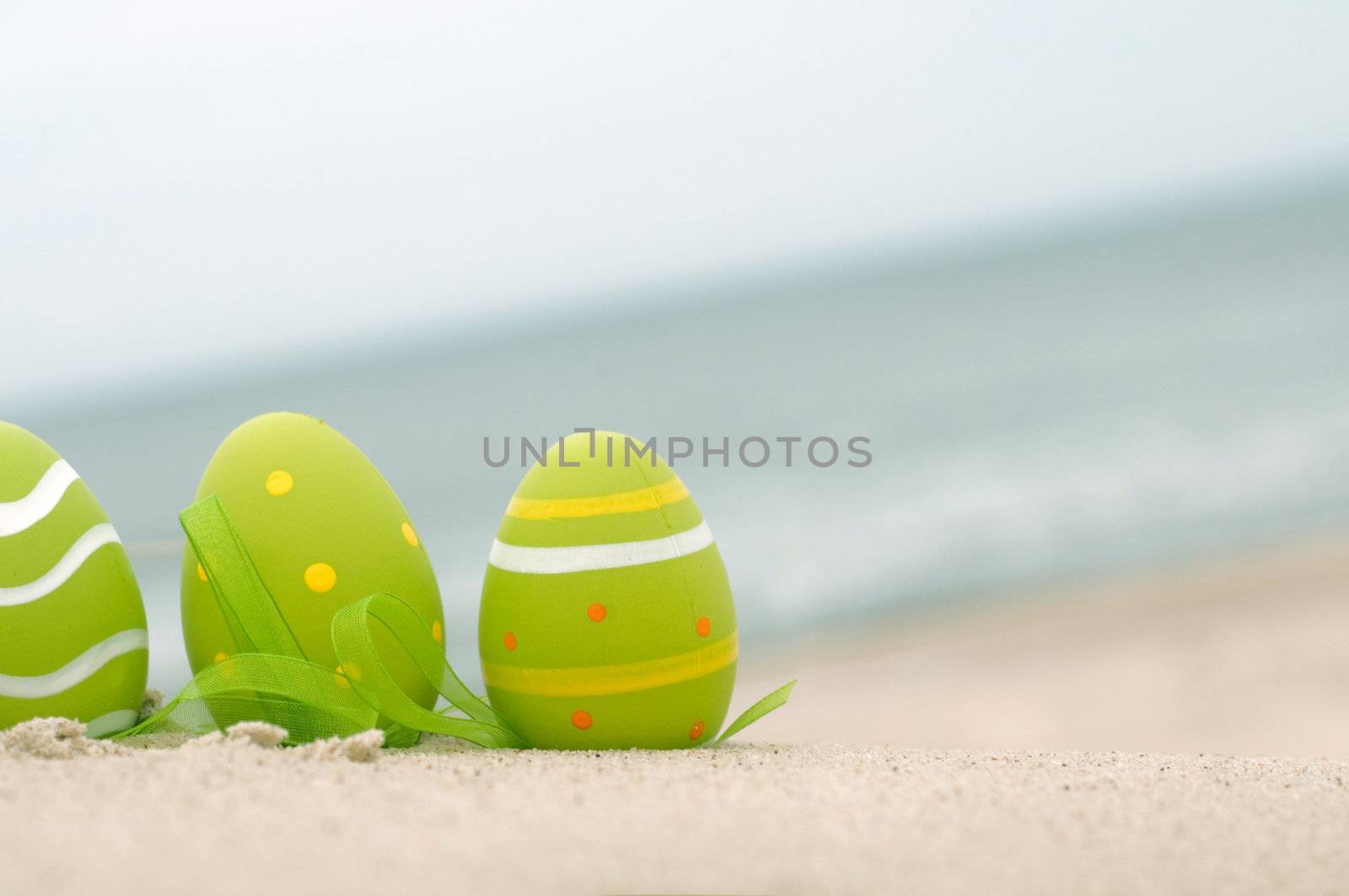 Easter decorated eggs on sand by photocreo