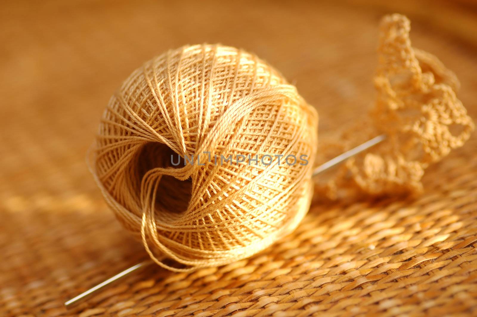Yarn ball with needle on wicker table
