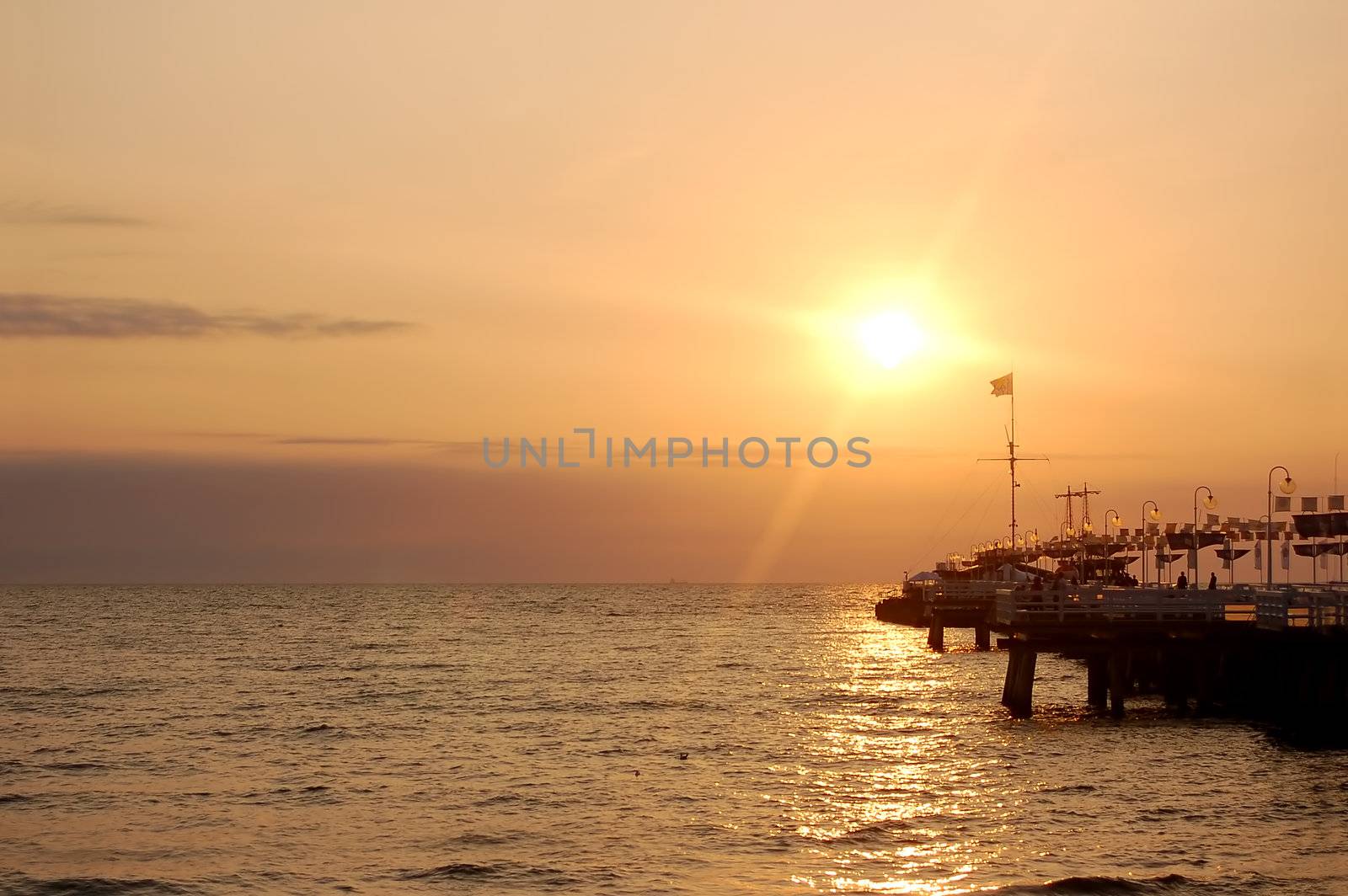 View of sunrise ocean with pier