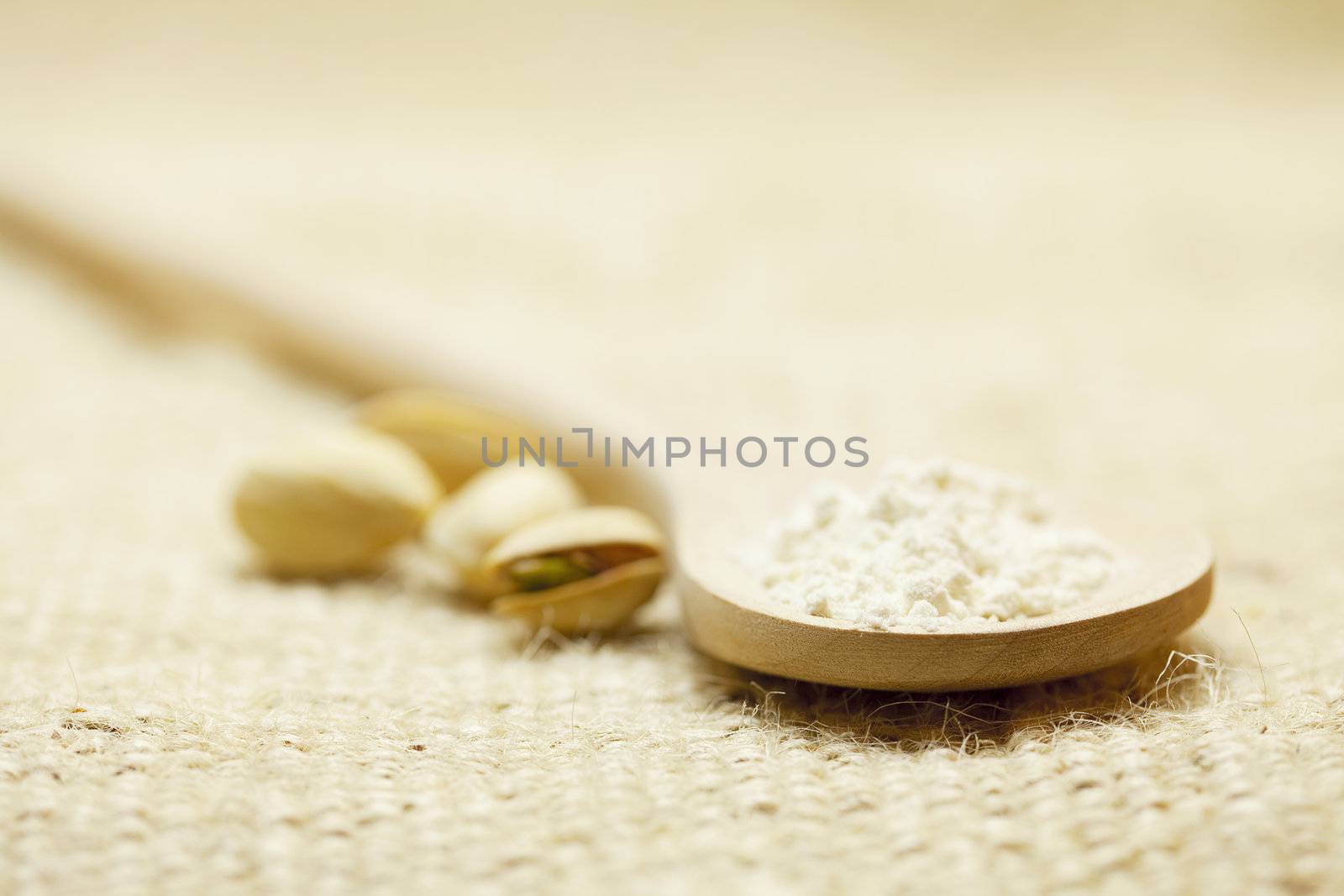 spoon of flour and Pistachios on linen fabric by jannyjus