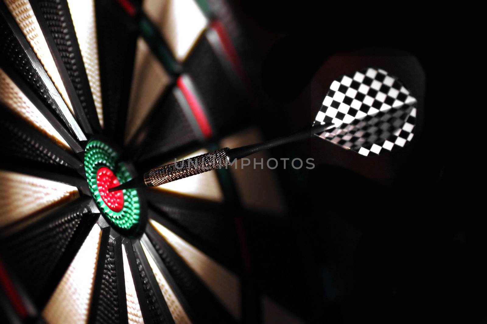 One arrow in the centre of a dart board. Shallow depth of field