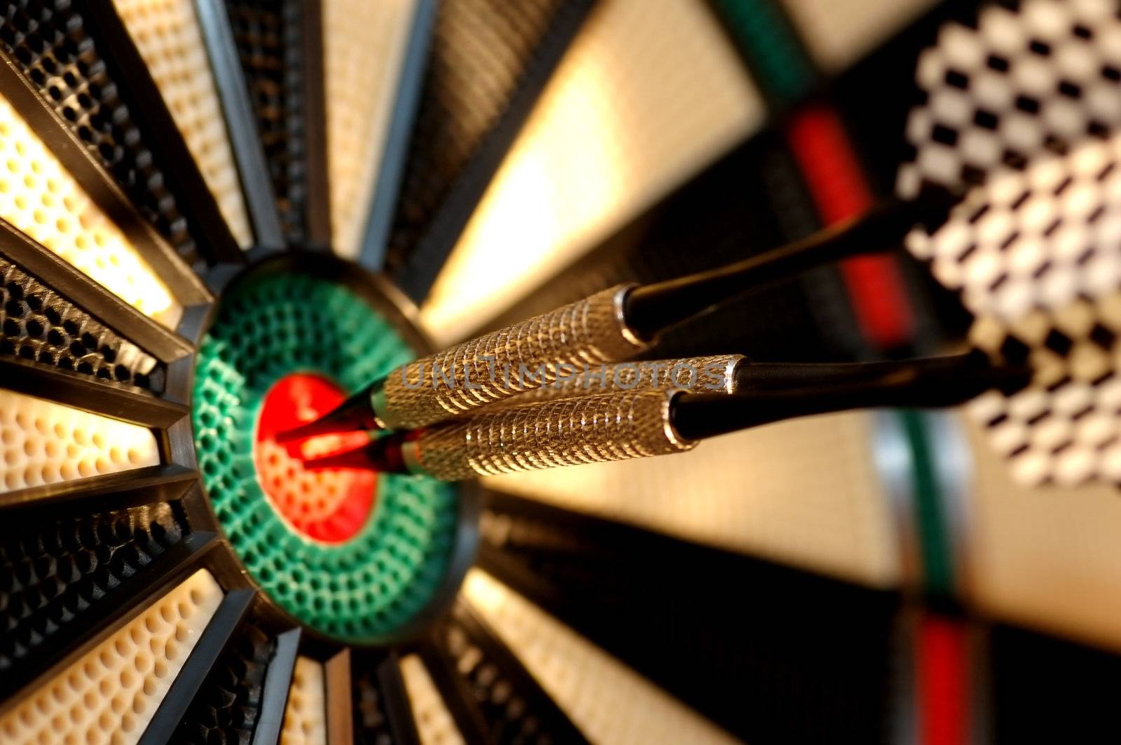 Three arrows in the centre of a dart board by photocreo